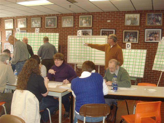 Rotarians taking calls and updating the bids on the boards.